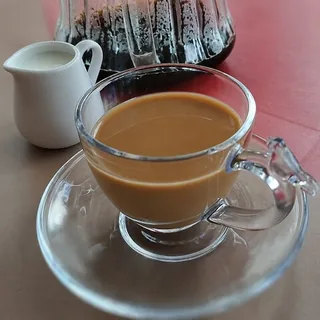 Café coado servido com uma jarrinha de leite fervido
