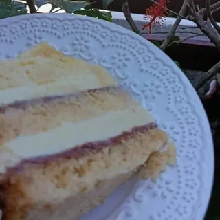 Fatia de bolo quatro leites com geleia de morango