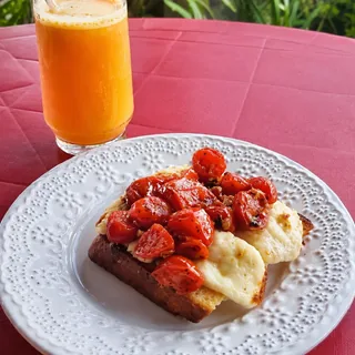 Pão da casa, dourado na chapa com manteiga, tomate confit e queijo Minas derretido