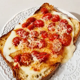 Pão da casa, dourado na chapa com manteiga, tomate confit e queijo coalho